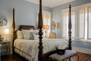 a bedroom with a large bed with a wooden post at Morgan and Wells Bed and Breakfast in Shelby