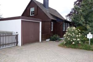 una casa marrone e bianca con garage di Hexenhaus a Neheim-Hüsten