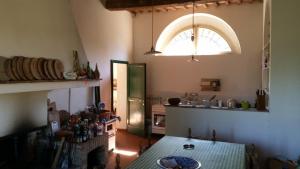シエナにあるvilla montalcino palazzina castelverdelliのキッチン(テーブル、冷蔵庫付)、窓が備わります。