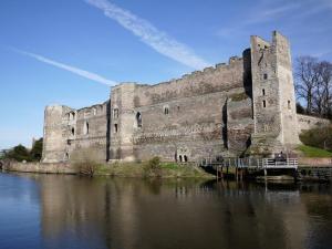 a large castle sitting next to a body of water at St Leonards cottage in Newark-on-Trent