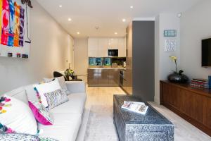 a living room with a couch and a table at Sleek Arty Apartment in London