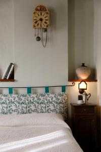 1 dormitorio con 1 cama y reloj en la pared en Agriturismo Valpietro, en Urbania