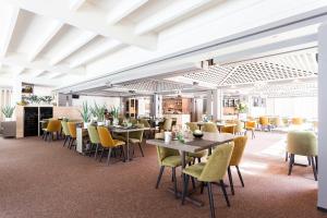 a dining room with tables and yellow chairs at Val d'Arimont Resort in Malmedy