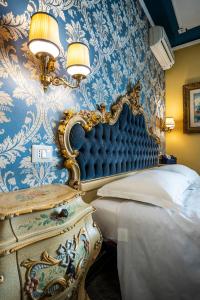 ein Schlafzimmer mit einer blauen und weißen Damasttapete in der Unterkunft La Bauta in Mestre