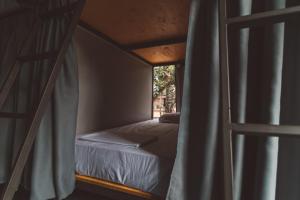 a bunk bed in a room with a window at Laika Hostel in Camburi