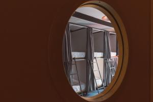 a mirror looking into a room with beds at Laika Hostel in Camburi