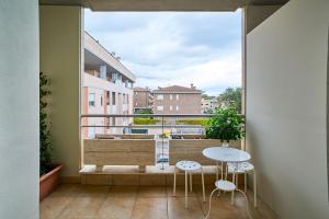 a balcony with a table and chairs and a large window at Arcibaleno in Sabaudia