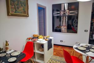 une salle à manger avec des chaises rouges et une table avec de la nourriture. dans l'établissement Bb Tube, à Gênes