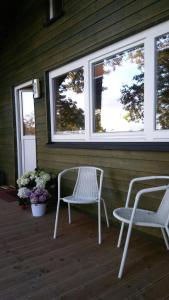 two chairs and a table on a porch with windows at Ferienhof Ohlenbusch in Worpswede