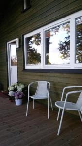 2 Stühle und ein Tisch auf einer Veranda mit Fenstern in der Unterkunft Ferienhof Ohlenbusch in Worpswede