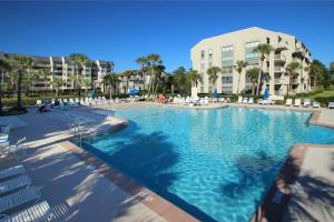 uma grande piscina com cadeiras e um edifício em Shorewood Condos em Hilton Head Island