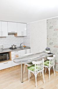 a kitchen with white cabinets and a table and chairs at City Centre Apartment in Odesa