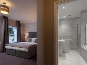 a bedroom with a bed and a bathroom with a shower at Elfordleigh Hotel in Plymouth