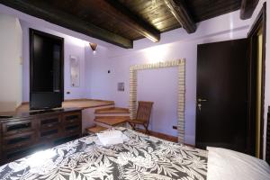 a bedroom with a bed and a television and a desk at Residenza Sant'Andrea in Campobasso