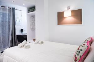 ein Schlafzimmer mit einem weißen Bett und einem Fenster in der Unterkunft Tulip #Colony city center in Thessaloniki