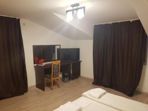 a bedroom with black curtains and a desk and a bed at Casa Lions in Timişoara
