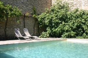 duas cadeiras sentadas ao lado de uma piscina em La Rôse em Saint-Gervasy