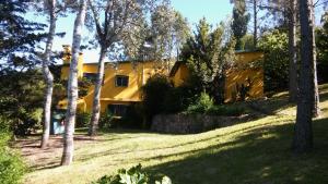 una casa amarilla en el bosque con árboles en Rancho Taxco en El Pueblito