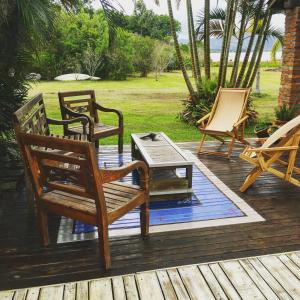 a group of chairs and a table on a deck at Vieja Hacienda in Praia do Rosa