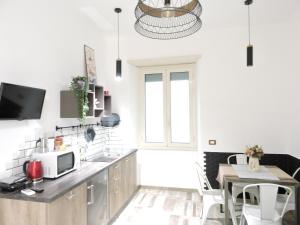 a kitchen with white walls and a table with a microwave at Domus Angelica in Rome