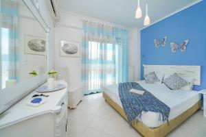 a bedroom with a bed and a bathroom with butterflies on the wall at Lina's Sea View Apartments in Limenas