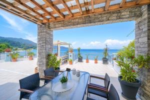 a patio with a table and chairs and the ocean at Lina's Sea View Apartments in Limenas