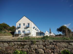 a large white house behind a stone wall at Le Roc'h Ar Mor in Lampaul