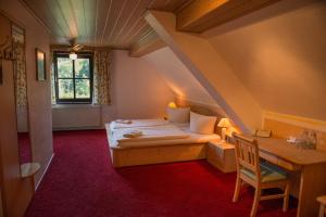 a bedroom with a bed and a desk and a window at Flair-Waldhotel Mellestollen in Saalfeld +132 photos