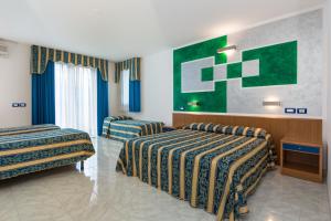a hotel room with two beds and a painting on the wall at Hotel Centrale in Latisana