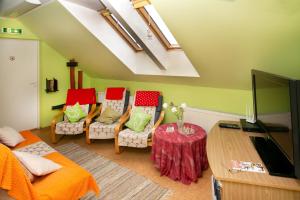 - un salon avec un canapé, des chaises et une télévision dans l'établissement Guesthouse Laurits, à Kuressaare