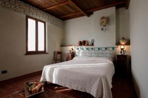 a bedroom with a bed with a blue and white bedspread at Agriturismo Valpietro in Urbania