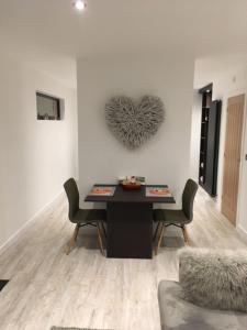 una sala de estar con una mesa y un corazón en la pared en Parkknott Retreat Luxury Lodge with Private Hot Tub en Askam in Furness