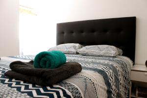 a bed with a black headboard and a green pillow at Miradouro's Loft in Setúbal