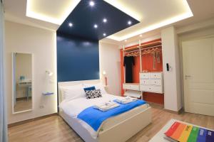 um quarto com uma cama grande e uma parede azul em Vacuna Pleasant Rooms em Nápoles