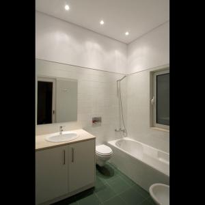 Saldanha Apartment في لشبونة: حمام مع حوض وحوض استحمام ومرحاض