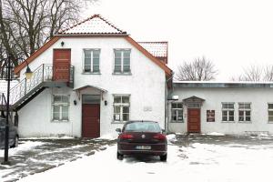 ein Auto, das vor einem Haus im Schnee parkt in der Unterkunft Guesthouse Laurits in Kuressaare