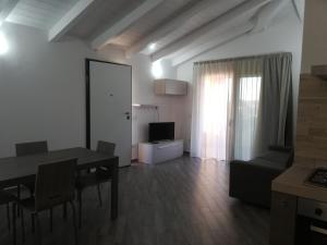 a living room with a dining table and a television at Casa Vacanze Porto Istana in Murta Maria