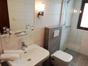 a white bathroom with a sink and a toilet at Hotel Reitherhof in Reith bei Seefeld
