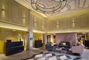 eine Lobby mit Sofas, Stühlen und einer Decke in der Unterkunft Citadines Trafalgar Square in London