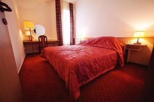 a hotel room with a bed with a red bedspread at Apartments Vila Barka in Portorož