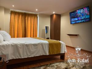 a bedroom with a bed and a flat screen tv at San Rafael Hotel in Guaranda