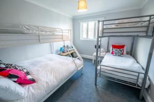ブライトン＆ホーブにあるPier Court Apartments Brightonのベッドルーム1室(二段ベッド2台、窓付)が備わります。