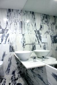 2 lavabos en un baño con paredes de mármol en Miradouro's Loft, en Setúbal