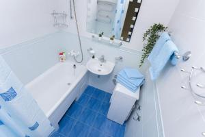 a bathroom with a white tub and a sink at Apartment near Zybitskaya in Minsk
