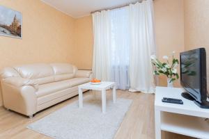 salon z kanapą i telewizorem w obiekcie Apartment near Zybitskaya w Mińsku