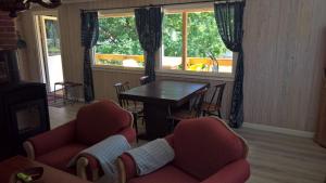 un soggiorno con tavolo, sedie, tavolo e finestre di Eikheim a Birkeland