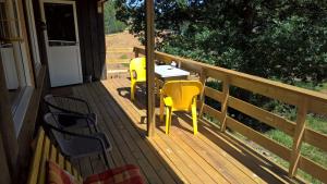 a porch with two yellow chairs and a table at Eikheim in Birkeland