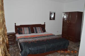 a bedroom with a bed and a dresser at Sukuta Nema Guest House in Bathurst