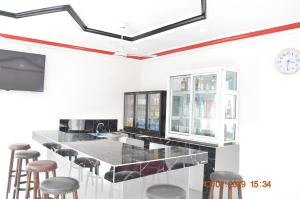 Sukuta Nema Guest House في بانجول: مطبخ مع بار مع كراسي وساعة