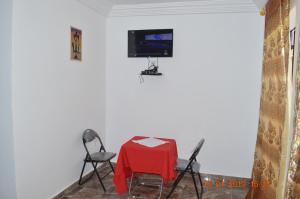 a room with a table and two chairs and a television at Sukuta Nema Guest House in Bathurst